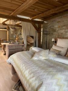 a bedroom with a large bed and a stone wall at Lark in Schleibnitz