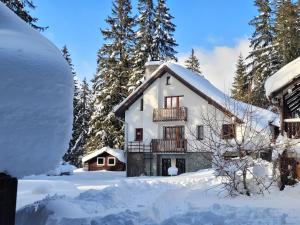 une maison recouverte de neige avec des arbres en arrière-plan dans l'établissement Chaty Tatra, à Tatranska Strba