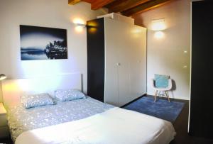 Un dormitorio con una cama y una silla dentro. en Casa Franka Garda Lake View, en Toscolano Maderno
