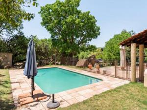 uma piscina com um guarda-sol num quintal em 1 Bedroom Cottage em Midrand