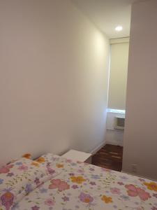 1 dormitorio con 1 cama con colcha de flores en Melhor de Copacabana en Río de Janeiro