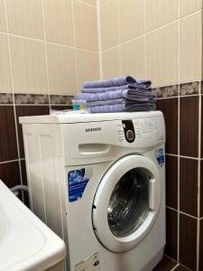 eine Waschmaschine mit blauen Handtüchern darüber in der Unterkunft Элитная квартира возле гипермаркета Дины in Aqtöbe