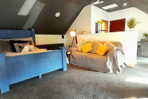 1 dormitorio con cama azul y almohadas amarillas en Serenity Lodge, 