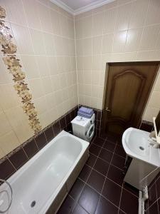 ein Badezimmer mit einer Badewanne, einem WC und einem Waschbecken in der Unterkunft Элитная квартира возле гипермаркета Дины in Aqtöbe
