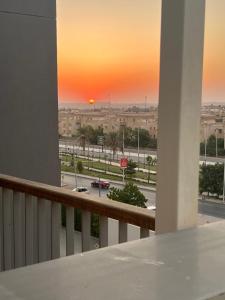 a sunset from a balcony with a view of a street at Luxury stay roof top in 6th Of October +3 photos