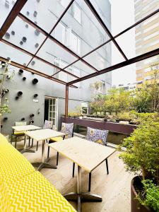 un patio con mesas y sillas y un edificio en The Grace Hotel, en Bogotá
