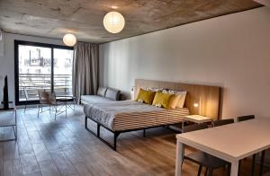 Un dormitorio con una cama, un sofá y una mesa. en Babel Botánico, en Buenos Aires