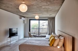 Un dormitorio con una cama y una ventana grande. en Babel Botánico, en Buenos Aires
