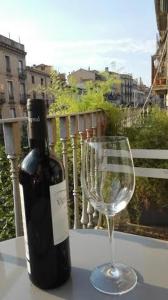 a bottle of wine and a wine glass on a table at Bed & Breakfast Bells Oficis in Girona