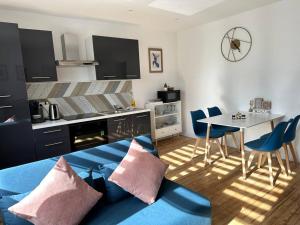 a living room with a blue couch and a table at Gîte Le Bredala in Bennwihr