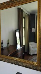 a mirror reflecting a room with a tub and a bedroom at Bed & Breakfast Bells Oficis in Girona