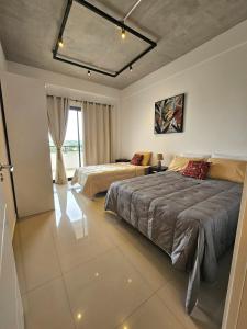 a bedroom with two beds and a large window at Apartamento confortable in Ciudad del Este
