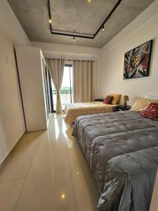 a bedroom with two beds and a living room at Apartamento confortable in Ciudad del Este