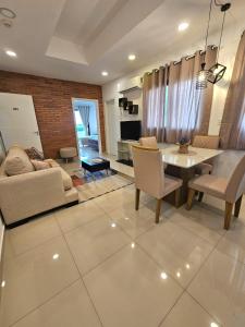 ein Wohnzimmer mit einem Sofa, einem Tisch und Stühlen in der Unterkunft Apartamento confortable in Ciudad del Este