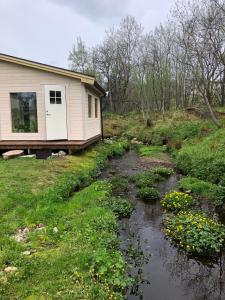 a house with a creek in front of it at Relaxing cabin in Gravdal