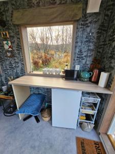 a kitchen with a window and a desk and a chair at Relaxing cabin in Gravdal