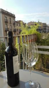 una botella de vino y una copa de vino en una mesa en Bed & Breakfast Bells Oficis, en Girona
