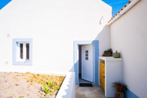 una casa bianca con pareti blu e bianche di Casa do Meio a Cela