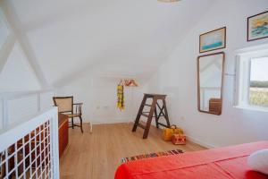 una camera da letto con un letto, uno specchio e una sedia di Casa do Meio a Cela