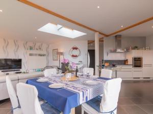 a dining room with a blue table and white chairs at Holiday Home Maison de Plain Pied - Vue Mer - TRP106 by Interhome in Kergador