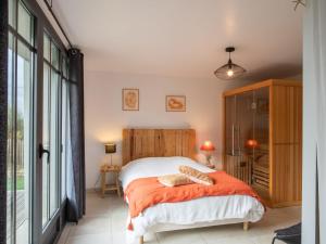 ブリニョガン・プラージュにあるHoliday Home Le Petit Bonheur - BRP210 by Interhomeのベッドルーム1室(オレンジ色の毛布付きのベッド1台付)