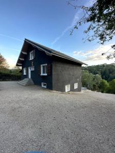 a blue house with a gravel driveway at River Villa with amazing view + Jacuzzi, Garden, Forest access in Vétraz-Monthoux