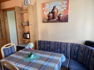 a table with a blue couch and a table with flowers on it at Holiday Home Am Walde-1 by Interhome in Dobbertin