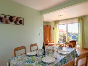 Holiday Home Tal ar Mor - LPU100 by Interhome في لو بولدو: طاولة غرفة الطعام مع أطباق وزجاجة من النبيذ