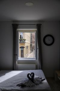 a bedroom with a window with two hearts on a bed at Euro Square Studios in Zagreb