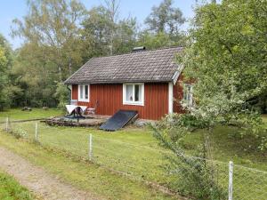 una casa roja con una valla delante en Holiday Home Angsjö Torp by Interhome, en Backaryd