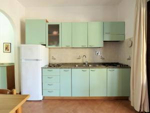 カポリーヴェリにあるApartment Oasis 3 by Interhomeのキッチン(緑のキャビネット、白い冷蔵庫付)