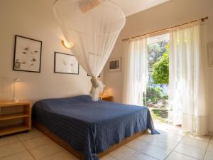 um quarto com uma cama com um cobertor azul e uma janela em Villa La Colline - GAR250 by Interhome em Garéoult