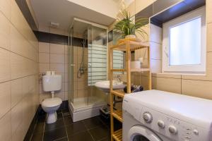 a bathroom with a toilet sink and a washing machine at Euro Square Studios in Zagreb