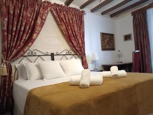 a bedroom with a large bed with white pillows at Casa Rural La Casona in Urrea de Gaen