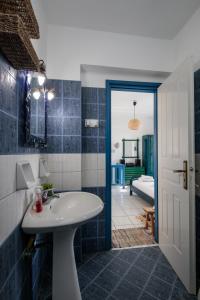 a bathroom with a white sink and a tub at Nefeli in blue in Plaka +46 photos