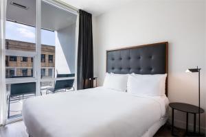 a bedroom with a large bed and a large window at Level Downtown LA South Olive in Los Angeles