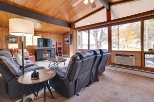 a living room with leather chairs and a table at Otsego Lake Getaway with Community Boat Ramp! in Gaylord