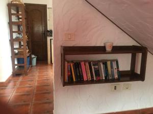 un estante de libros junto a una pared con libros en Casa La Florida en Calera