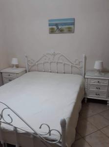 1 dormitorio con 1 cama blanca y 2 mesitas de noche en ANNA, en Kastrisiánika