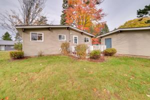 a house with a fence in a yard at Otsego Lake Getaway with Community Boat Ramp! in Gaylord