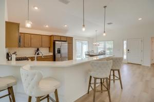 una cocina con encimeras blancas y taburetes de bar en Community Pool and Tennis Court Gem in The Villages, en Leesburg