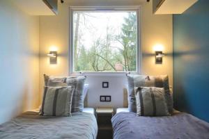 zwei Betten in einem Zimmer mit Fenster in der Unterkunft La Cabane du Pêcheur à 10min de Disneyland Paris - Cabane & Cabanon in Chalifert