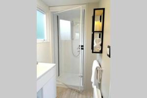 ein Badezimmer mit Dusche und weißer Badewanne in der Unterkunft La Cabane du Pêcheur à 10min de Disneyland Paris - Cabane & Cabanon in Chalifert + 8 Fotos