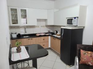 a small kitchen with a black refrigerator and a table at Apart Luis in Penha