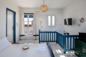 a bedroom with a blue and white bed and a balcony at Nefeli in blue in Plaka