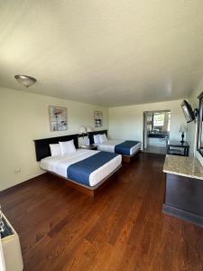 una grande camera con due letti e pavimenti in legno di Hotel Quinta San Carlos Inn a Manuel Valdez