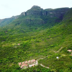 einen großen grünen Hügel mit Häusern darauf in der Unterkunft Green Chales - Vale do Capão in Vale do Capao