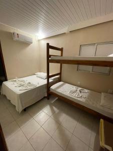 מיטה או מיטות קומותיים בחדר ב-Morro de São Paulo Hospedagens