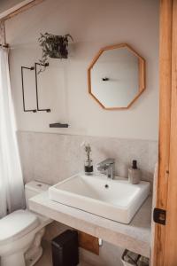 a bathroom with a sink and a toilet and a mirror at Casa Faustina - Templo de la Luna in Cusco