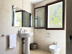 ein Badezimmer mit einem Waschbecken, einem WC und einem Spiegel in der Unterkunft Sueños de Monachil in Monachil